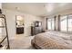 Bedroom featuring soft carpeting, window with natural light, and en-suite bathroom at 8833 Meade St, Westminster, CO 80031
