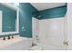 Bathroom featuring blue walls, a bathtub with shower, and a vanity sink at 8731 Wildrye Cir, Parker, CO 80134