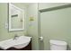 Half bathroom with a mirror above the sink and light green walls at 8731 Wildrye Cir, Parker, CO 80134