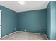 Bedroom featuring blue painted walls, light gray carpet, and a minimalist aesthetic at 8731 Wildrye Cir, Parker, CO 80134