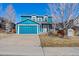 Daytime view of charming two-story home with blue siding, attached garage, and well-maintained front yard at 8731 Wildrye Cir, Parker, CO 80134