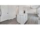 Open kitchen with vinyl wood-look floors, white cabinets, and island, and staircase to second story at 5237 S Malaya Way, Centennial, CO 80015