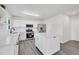 Bright kitchen with an island, stainless steel appliances, white cabinets, vinyl wood-look flooring and lots of light at 5237 S Malaya Way, Centennial, CO 80015