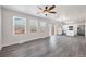 Open-concept living room featuring natural light, vinyl wood-look flooring, and a view into the kitchen with white cabinets at 5237 S Malaya Way, Centennial, CO 80015