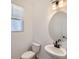 Stylish powder room with a pedestal sink and round mirror at 9639 Browns Peak Cir, Littleton, CO 80125