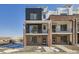 Modern two-story townhome with brick and black exterior, balcony, and walkway at 9639 Browns Peak Cir, Littleton, CO 80125