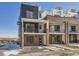 Modern two-story townhome with brick and black exterior, balcony, and walkway at 9639 Browns Peak Cir, Littleton, CO 80125