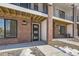 Front entrance of townhome with brick exterior and modern door at 9639 Browns Peak Cir, Littleton, CO 80125