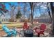 Landscaped backyard showcasing colorful Adirondack chairs around a fire pit, perfect for outdoor relaxation at 1351 Reed St, Lakewood, CO 80214