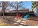 A cozy backyard gathering space with colorful Adirondack chairs and a fire pit for relaxation and entertainment at 1351 Reed St, Lakewood, CO 80214