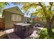 Backyard patio with a hot tub, outdoor dining set and lush landscaping at 1351 Reed St, Lakewood, CO 80214