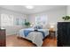 Cozy bedroom featuring hardwood floors, two bright windows, and neutral decor at 1351 Reed St, Lakewood, CO 80214