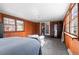 Bedroom featuring a gray carpet, wood paneled walls, and natural light at 1351 Reed St, Lakewood, CO 80214