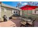 Backyard patio area featuring an outdoor seating area with a grill, table and chairs, and a red umbrella at 1351 Reed St, Lakewood, CO 80214