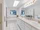 Bright bathroom features a skylight, double sinks, and tile flooring at 6102 E Yale Ave, Denver, CO 80222