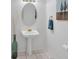 Bathroom featuring a pedestal sink, oval mirror, and neutral wall decor at 6102 E Yale Ave, Denver, CO 80222