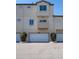 Three-story townhouse with garages beneath, simple landscaping, and neutral paint at 6102 E Yale Ave, Denver, CO 80222