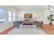 Neutral living room features hardwood floors, modern furniture, and lots of natural light from the many windows at 6102 E Yale Ave, Denver, CO 80222