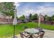 Lush backyard with a patio, featuring a glass table with wicker chairs and an umbrella for outdoor enjoyment at 8915 Edgewood Ln, Highlands Ranch, CO 80130