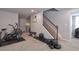Basement workout area featuring free weights, exercise bike, bench, and wood stairs at 8915 Edgewood Ln, Highlands Ranch, CO 80130
