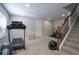 Basement workout area with treadmill, exercise bike and wood stairs at 8915 Edgewood Ln, Highlands Ranch, CO 80130