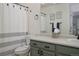 Bright bathroom featuring a vanity, toilet, and shower/tub combo with striped curtain at 8915 Edgewood Ln, Highlands Ranch, CO 80130