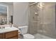 Modern bathroom with shower and wood vanity with bright sink and mirror at 8915 Edgewood Ln, Highlands Ranch, CO 80130