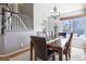 Dining area featuring hardwood floors, stylish chandelier, and staircase in the background at 8915 Edgewood Ln, Highlands Ranch, CO 80130