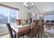 Elegant dining room with a long wood table, chandelier, and large window for natural light at 8915 Edgewood Ln, Highlands Ranch, CO 80130