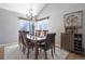 Elegant dining room featuring a chandelier, wooden table with six chairs, and a decorative cabinet at 8915 Edgewood Ln, Highlands Ranch, CO 80130