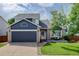 Charming two-story home with a well-maintained lawn, brick accents, and a dark blue garage door at 8915 Edgewood Ln, Highlands Ranch, CO 80130