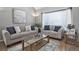 Comfortable living room with grey sofa and loveseat, bright window, and glass-topped coffee table at 8915 Edgewood Ln, Highlands Ranch, CO 80130