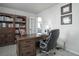 Well-lit office space with a spacious desk, ample shelving, and a comfortable chair for remote work at 8915 Edgewood Ln, Highlands Ranch, CO 80130