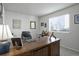Home office with a large wooden desk, comfortable chair, and natural light from the window at 8915 Edgewood Ln, Highlands Ranch, CO 80130