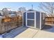 Outdoor storage shed features a gray exterior, white trim, and a concrete foundation at 8915 Edgewood Ln, Highlands Ranch, CO 80130
