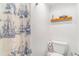 White bathroom featuring toilet, small shelf, and shower with nautical-themed curtain at 789 N Clarkson St # 406, Denver, CO 80218