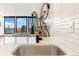 Modern kitchen featuring a stainless steel sink, black faucet, and view to living area at 789 N Clarkson St # 406, Denver, CO 80218