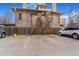 Exterior view of parking lot in front of the brick building behind a wooden fence with parking spots and two cars at 789 N Clarkson St # 406, Denver, CO 80218