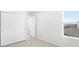 Bright bedroom features a window with blinds and a closet with paneled doors and neutral carpet at 571 Homestead Ave, Brighton, CO 80601
