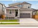 Charming two-story home with a covered porch, stone accents, and a two-car garage at 571 Homestead Ave, Brighton, CO 80601