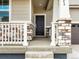 Inviting covered front porch with stone detailing on the columns and railing at 571 Homestead Ave, Brighton, CO 80601