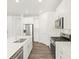 Bright kitchen features stainless appliances, white cabinetry, and a center island with sink at 571 Homestead Ave, Brighton, CO 80601