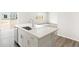 Kitchen island with sink features white cabinets, stainless appliances, and sleek countertops at 571 Homestead Ave, Brighton, CO 80601