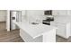 Bright kitchen features stainless appliances, white cabinetry, and a large center island with sink at 571 Homestead Ave, Brighton, CO 80601