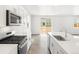 Bright kitchen features stainless steel appliances, white cabinets, and a modern backsplash at 571 Homestead Ave, Brighton, CO 80601