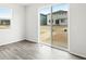 Bright living space with sliding glass door, wood-look flooring, and view of the backyard at 571 Homestead Ave, Brighton, CO 80601