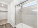 Modern glass shower with a tiled surround, small window, and chrome fixtures at 571 Homestead Ave, Brighton, CO 80601
