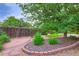 Serene backyard with a custom brick planter, river rock, stone path, and mature landscaping at 3544 Dyanna Dr, Thornton, CO 80241