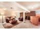 Inviting basement with a leather sofa, chairs, an area rug, and a wooden bar, perfect for relaxing or entertaining at 3544 Dyanna Dr, Thornton, CO 80241