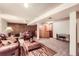 Inviting basement with a leather sofa, chairs, an area rug, and a wooden bar, perfect for relaxing or entertaining at 3544 Dyanna Dr, Thornton, CO 80241